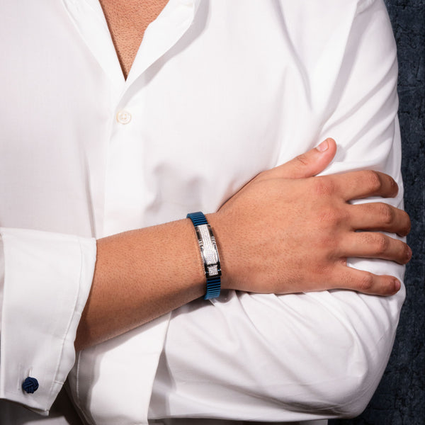 Person wearing a white shirt with rolled-up sleeves and a blue wristband.